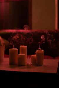 blown out candles on a wooden table with aesthetically pleasing smoke.