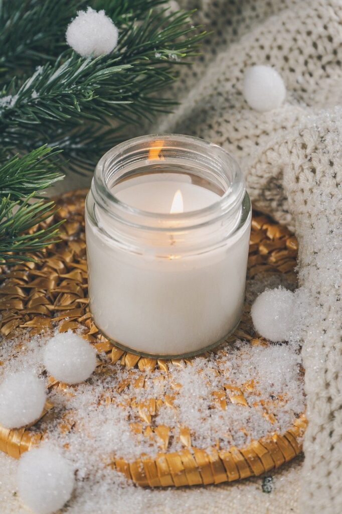 picture of a white candle in a "winter" decorative backdrop.