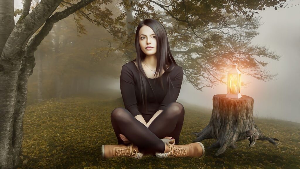 Woman in forest next to a candle